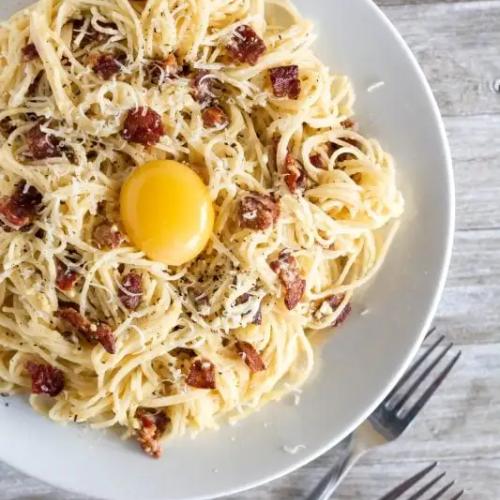 Carbonara spaghetti, pancetta or bacon, egg yolk, and pecorino cheese